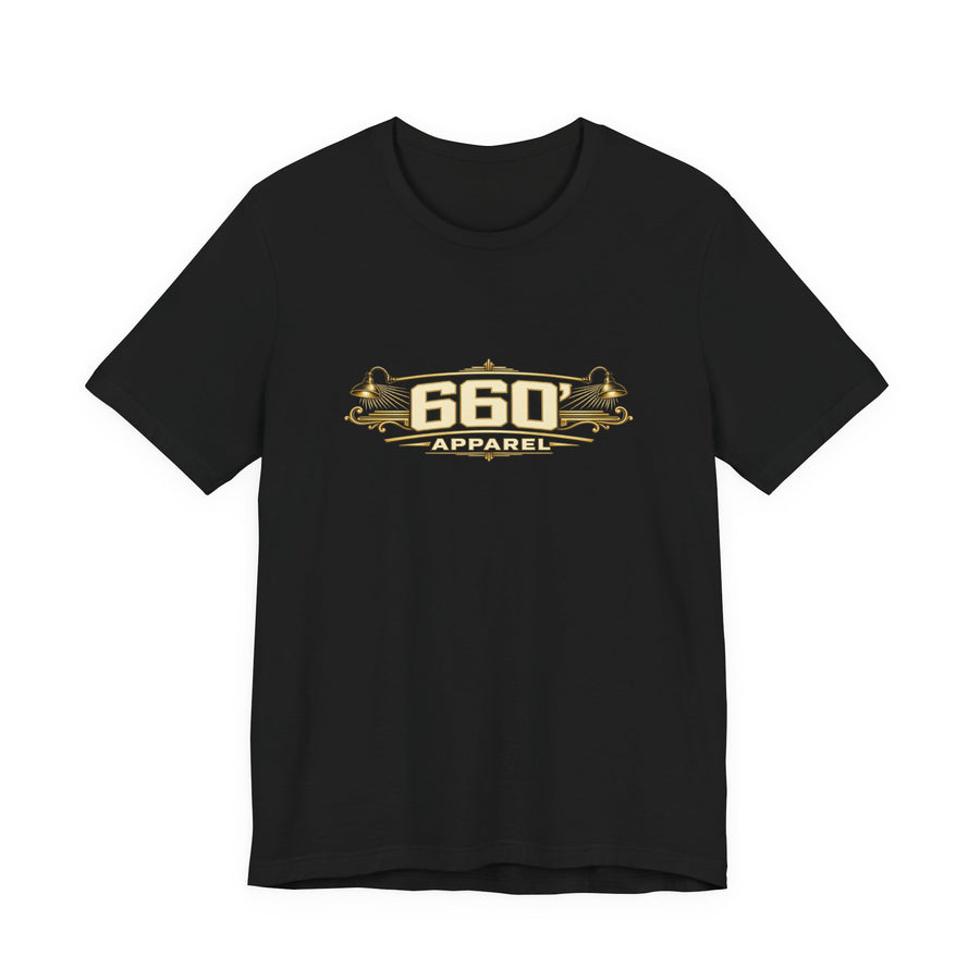 Front of black Bella+Canvas 3001 with wide cream-and-gold 660′ Apparel logo, shop lamps and engraved ornament