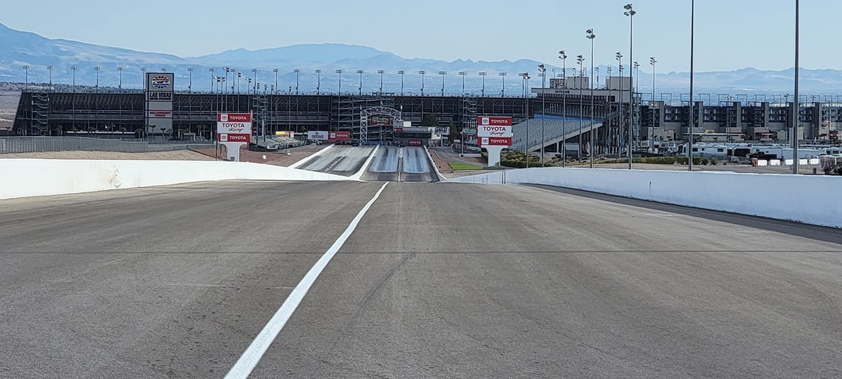 An empty drag strip stretching toward the mountains.
